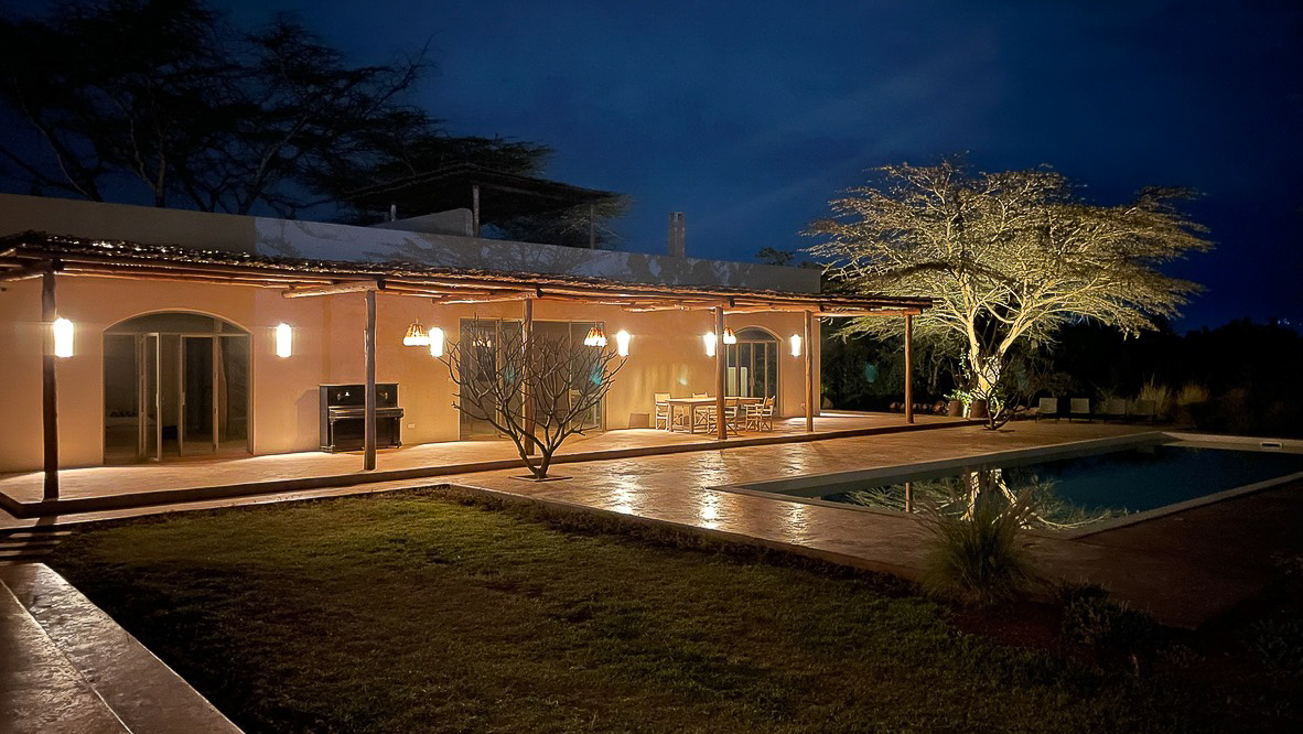 Pool House lit at night with lanterns along the veranda