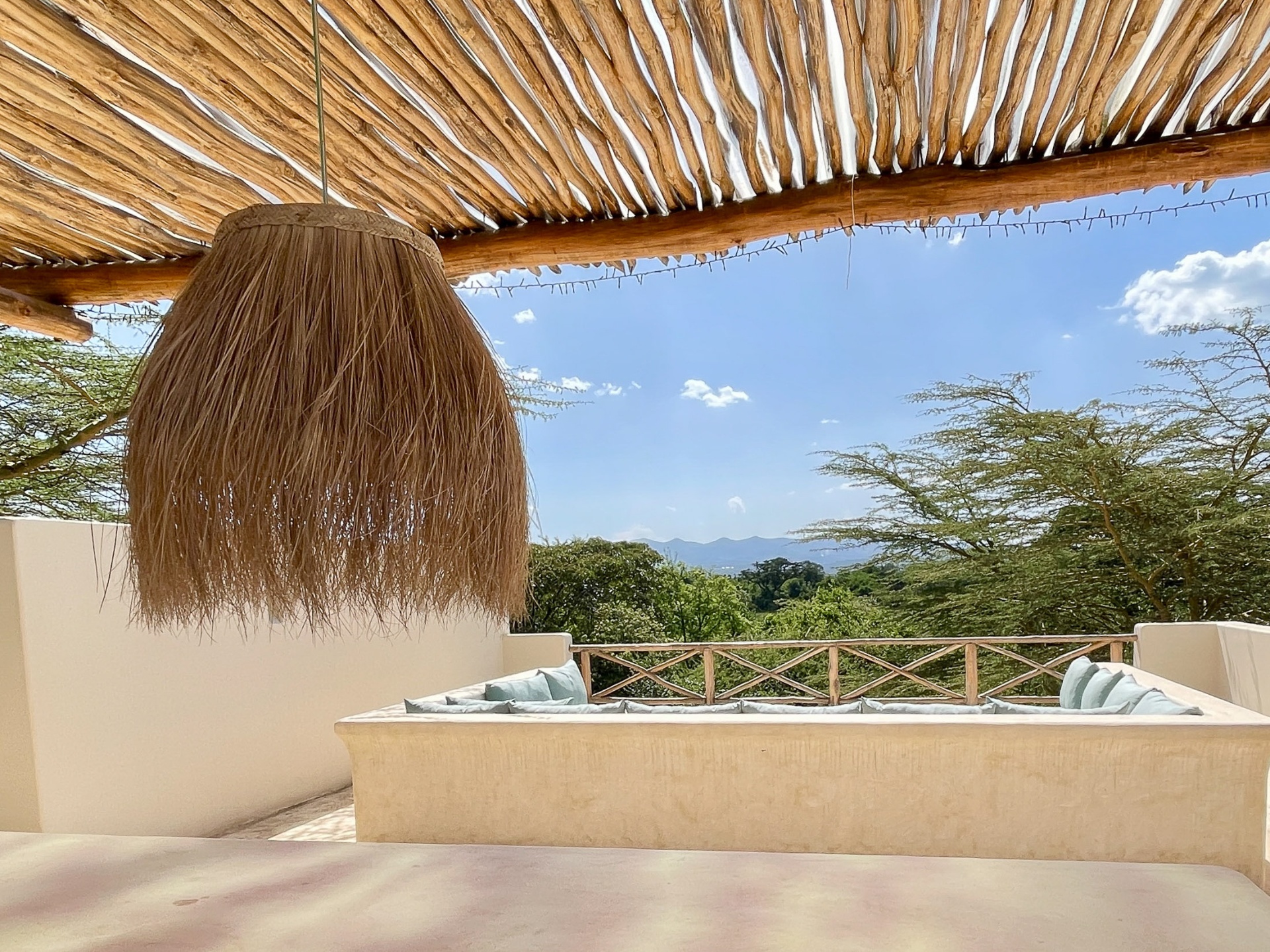 Rooftop bar with thatched pergola and acacia views