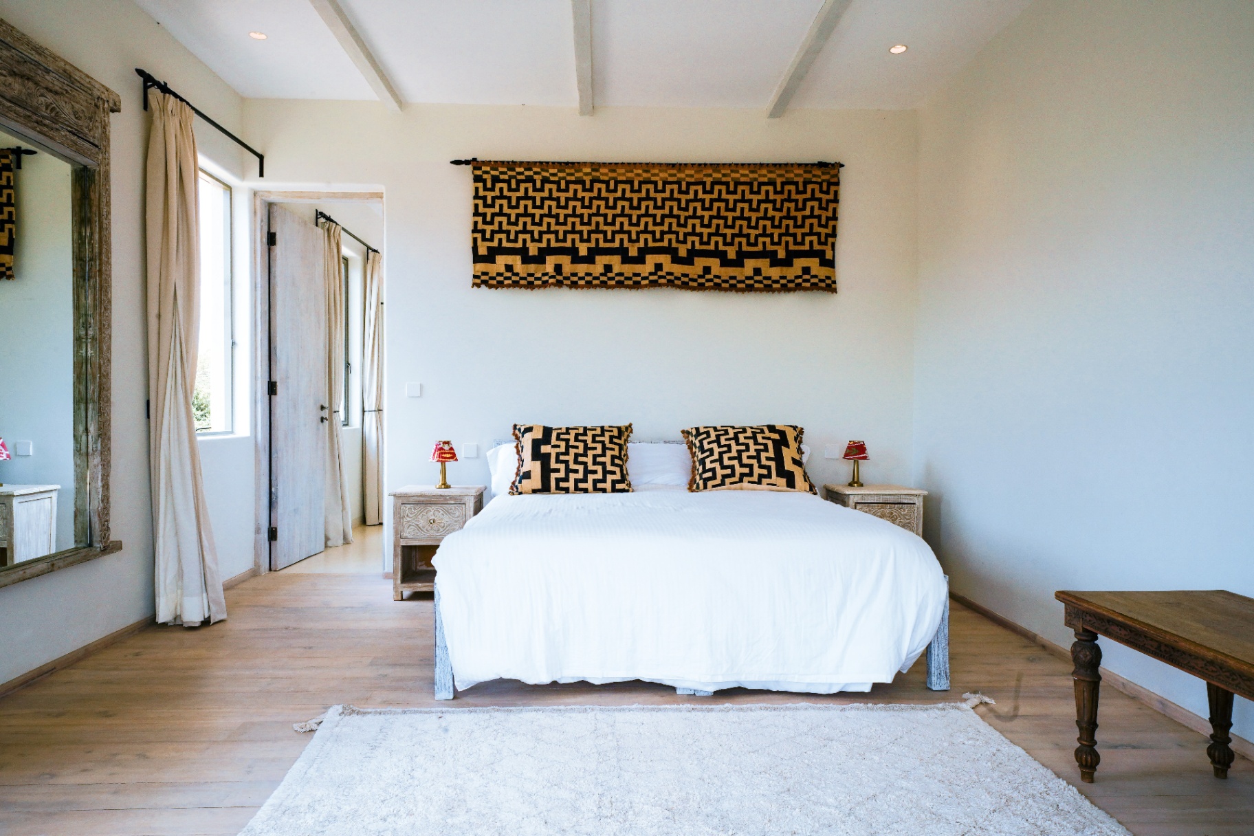 Bedroom with Kuba cloth wall hanging and king bed