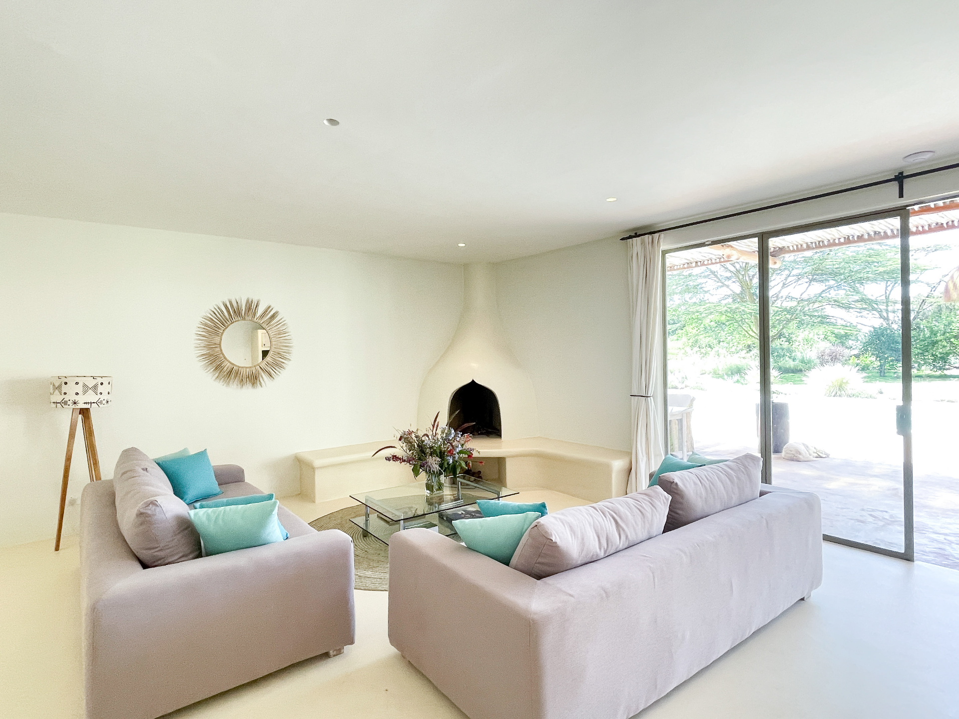 Open living room with sculptural fireplace and garden views